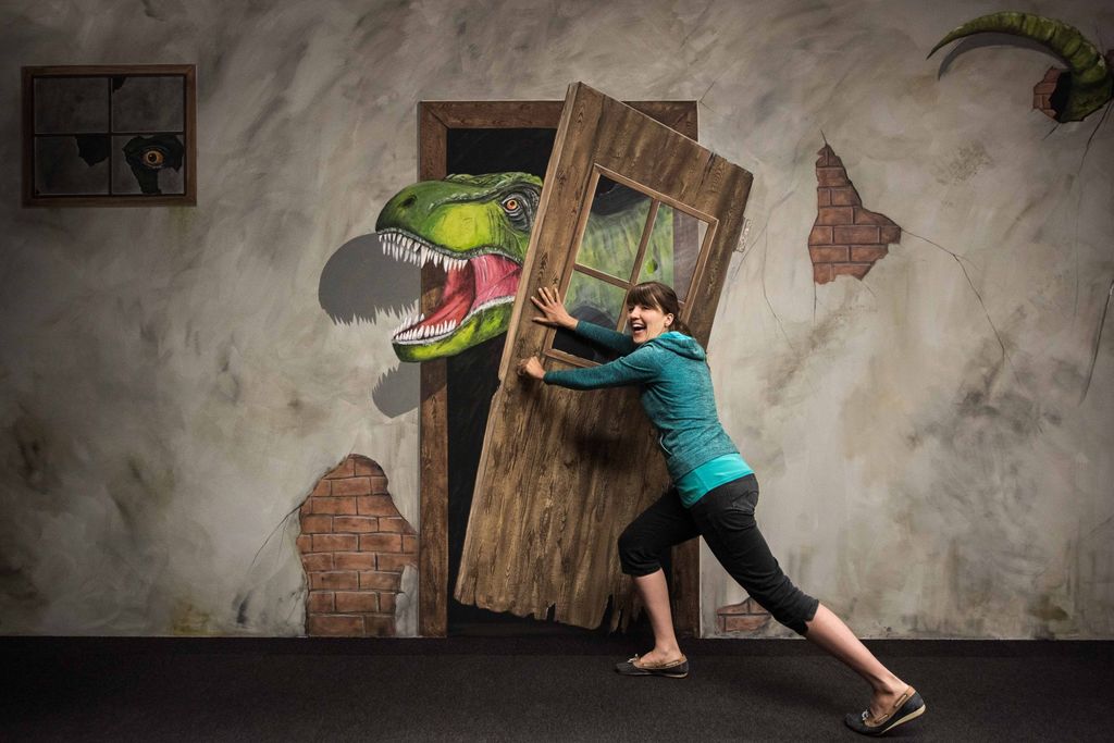 Alle Museumsgäste können genau wie Ausstellungsmacherin Dr. Julia Massier einmal selbst probieren dem Dino der Illusionsmalerei den Weg zu versperren.