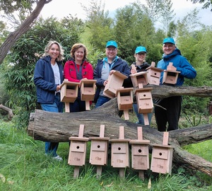 Zoodirektorin Astrid Stewin (links) und Nicole Sommer, Leiterin Corporate Citizenship bei thyssenkrupp Steel (2 v.l.), bei der Übergabe von Nistkästen. Insgesamt 65 Stück montierte das Zoo-Team gemeinsam mit Mitarbeitenden von thyssenkrupp Steel auf dem Zoogelände.