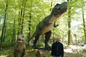 Nico Korte (Bereichsleiter Besuchererlebnis) steht inmitten des „Dinoversums“ bei den T-Rexen. Die Dino-Ausstellung ist ab dem 1. Mai im Zoo Osnabrück zu sehen.