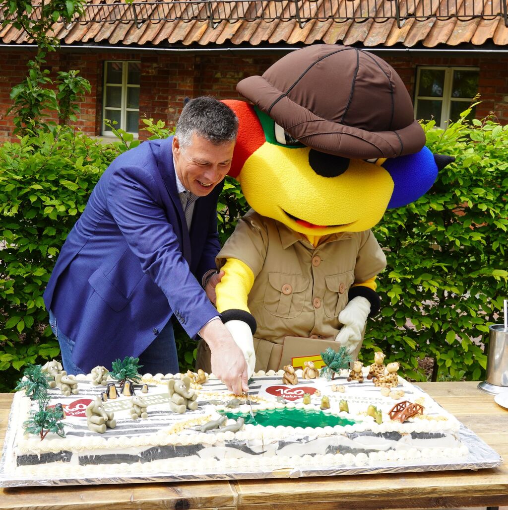 Zoo-Geschhrer Andreas MCasdorff und Zoo-Maskottchen Tatz Tatz schneiden die Geburtstags-Torte an.jpg